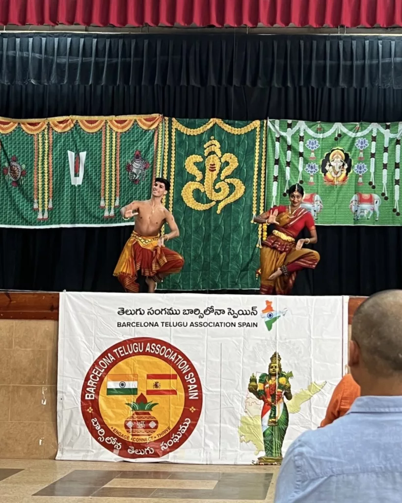 Group of dancers for the Ganesh Chaturthi Barcelona 2025. Performing for telugu asociation in Barcelona. Four girls and Francisco Valiente posing with a bharatanatyam pose on the stage while the audience is watching them dance.
