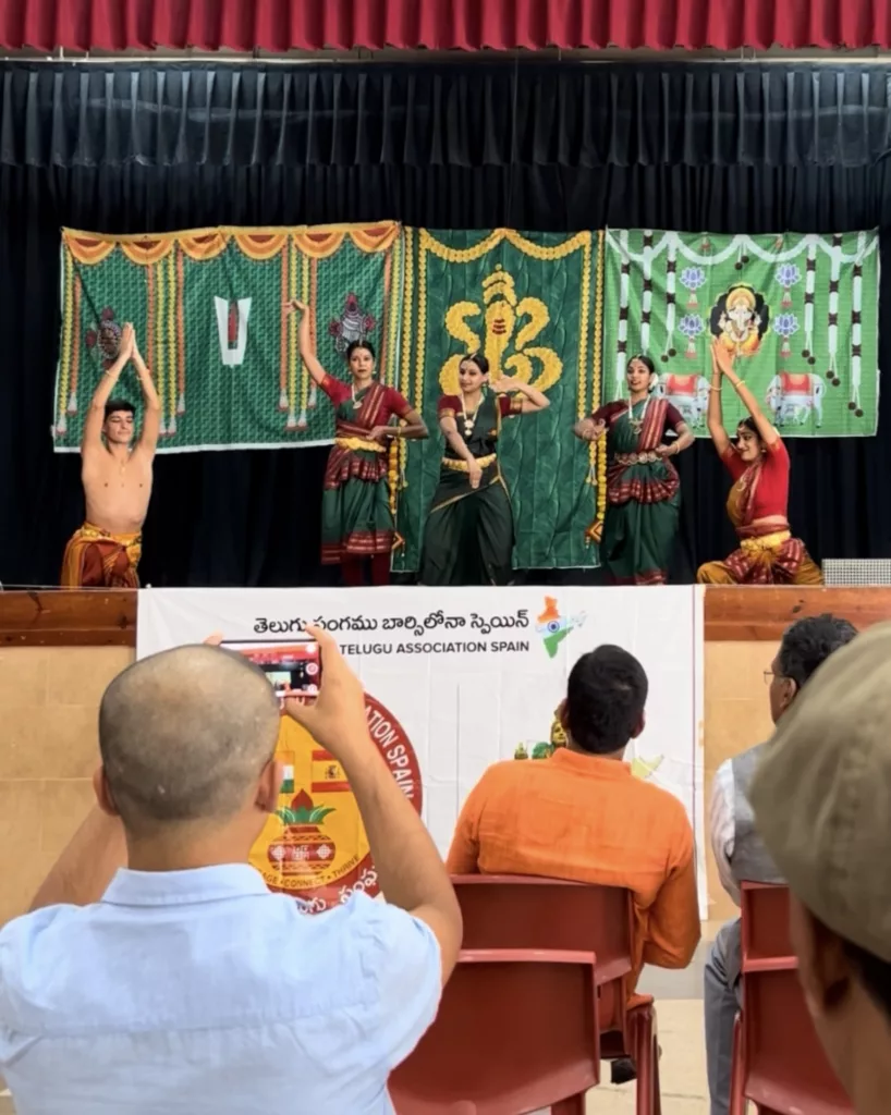 Group of dancers for the Ganesh Chaturthi Barcelona 2025. Performing for telugu asociation in Barcelona. Four girls and Francisco Valiente posing with a bharatanatyam pose on the stage while the audience is watching them dance.