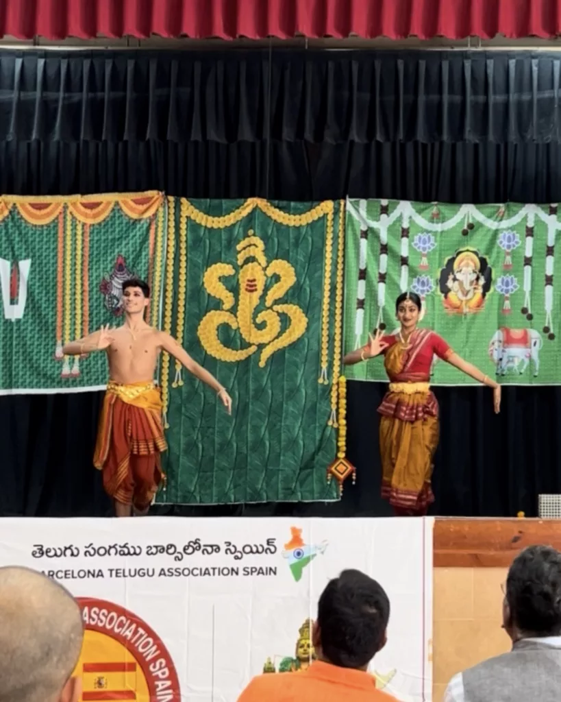 Group of dancers for the Ganesh Chaturthi Barcelona 2025. Performing for telugu asociation in Barcelona. Four girls and Francisco Valiente posing with a bharatanatyam pose on the stage while the audience is watching them dance.